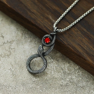 Détail du pendentif serpent vintage avec pierre de zircon rouge et textures ciselées