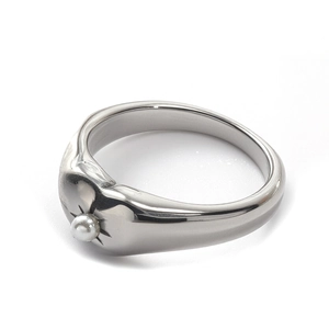 Detailed macro view of silver star ring with pearl inlay and polished metallic texture