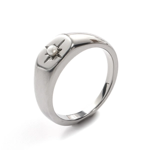 Detailed view of silver signet ring with starburst engraving and pearl inlay