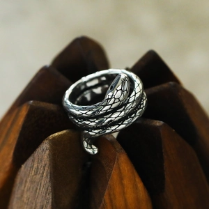 Macro shot of retro silver snake ring showing detailed scales and layered wrap design
