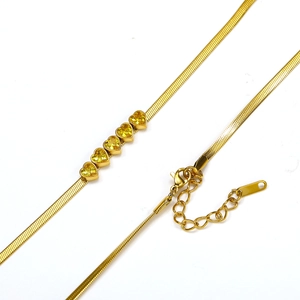 Detail van gouden slangenketting met vijf hartvormige gele zirkonia edelstenen