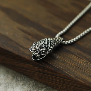 Vue macro du pendentif tête de serpent vintage montrant les détails des écailles et du métal punk