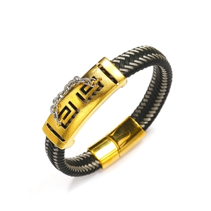 Macro view of braided leather rope bracelet with gold engraved metal and magnetic clasp