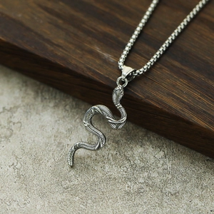 Vue macro détaillée du pendentif serpent en argent avec écailles et chaîne à maillons