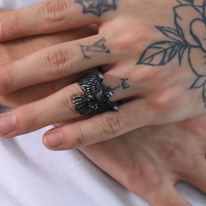 Close-up of vintage eagle ring in titanium steel showing fine feather details on finger