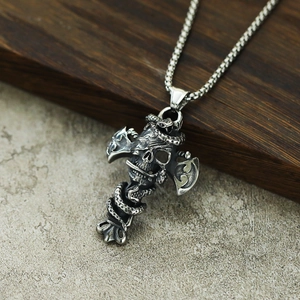 Gros plan d'un pendentif croix gothique en acier inoxydable avec crâne et serpent