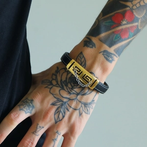Men's black leather bracelet with gold Greek key pattern and decorative silver chain