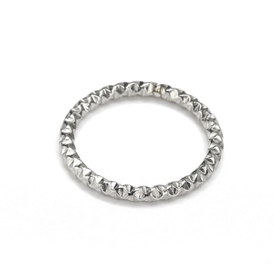 Macro view of textured titanium steel ring featuring sparkling diamond-cut grid pattern