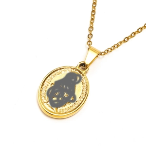 Detailed macro view of gold oval St. Benedict medal with embossed religious text on O-chain