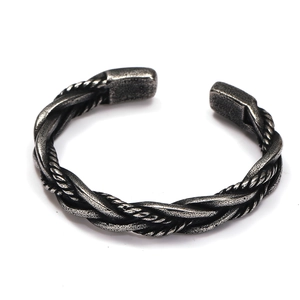 Close-up of vintage braided titanium steel cuff bracelet with antique silver finish texture
