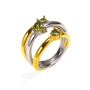 Vista macro dei zirconi verdi a forma di cuore su set di anelli placcati oro e argento