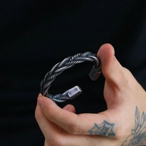Close-up of vintage braided titanium steel cuff bracelet with double twisted texture