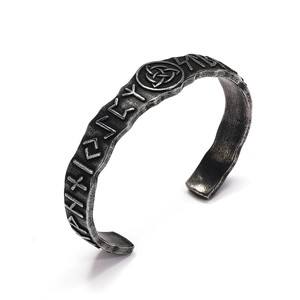 Macro detail of Nordic Viking cuff bracelet with rune engravings and Triquetra symbol