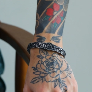Detailed view of Viking cuff bracelet featuring engraved runes and Celtic knot on model