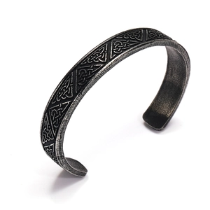 Detail of vintage Viking steel cuff bracelet with Celtic triangle patterns and aged finish