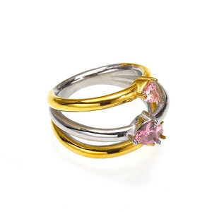 Dettaglio di anelli sovrapponibili bicolore con due pietre di zircone rosa a forma di cuore