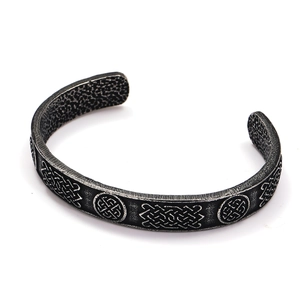 Detail of vintage Celtic knot relief and hammered texture on distressed steel bracelet