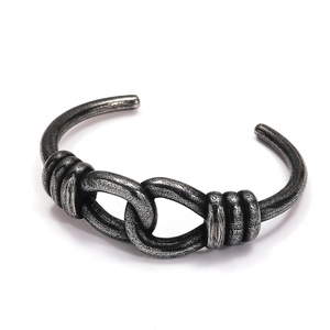 Detailed view of vintage oxidized titanium steel cuff bangle with twisted knot pattern