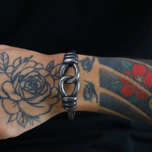 Macro detail of vintage Viking geometric steel cuff with braided texture and aged finish