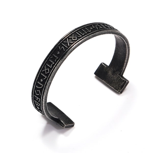 Macro view of vintage Viking cuff bracelet with Elder Futhark runes and textured edges
