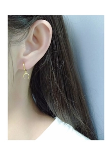 Detail of luxury gold moon crescent earrings with diamond inlay shown on model
