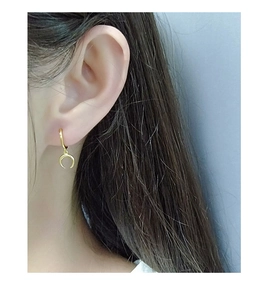 Close-up of a woman wearing a gold S925 sterling silver crescent moon hoop earring
