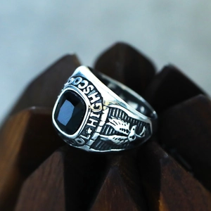 Macro shot of retro eagle ring with black gemstone and engraved High School text