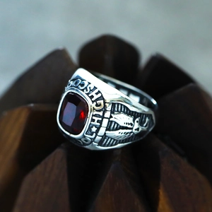Macro view of vintage silver eagle ring with square red gemstone and high school engraving