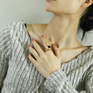 Close-up of vintage gold eagle ring with black gemstone on woman's finger