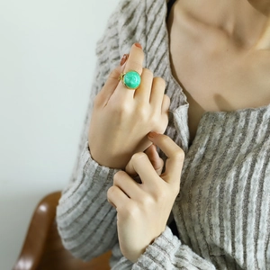 Close-up of 18k gold plated ring with round green oil-drop stone on model hand