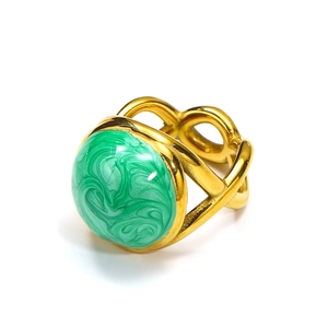 Close-up of golden ring with intertwined design and green marble-textured stone