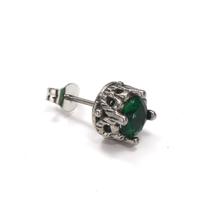 Clou d'oreille rétro en acier titane avec pierre verte et serti couronne sur fond blanc