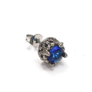 Détail macro d'une boucle d'oreille en titane vintage avec incrustation de zircon bleu