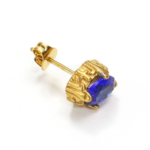 Makroaufnahme von Goldohrstecker mit tiefblauem Zirkon und dekorativer Reliefgravur