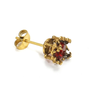Close-up of vintage golden zircon stud earrings with red stone and crown base detail
