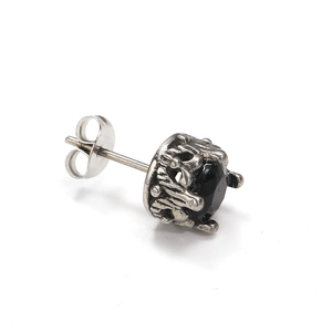 Détail d'une boucle d'oreille vintage avec sertissage texture lave et pierre noire