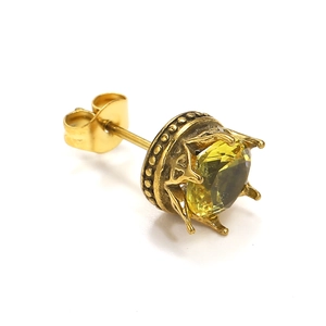 Makroansicht von Vintage Goldkronen-Ohrsteckern mit einem großen gelben Edelstein