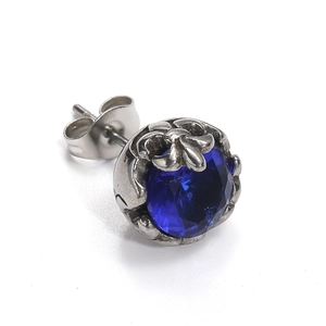 Macro d'une boucle d'oreille en acier titane rétro avec une pierre précieuse bleu foncé