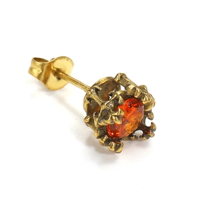Detailed macro view of vintage gold stud earring with amber zircon and filigree pattern