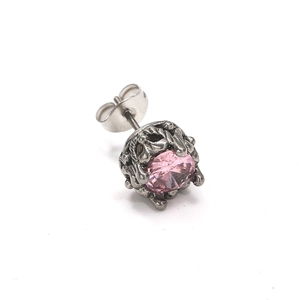 Détail d'un clou d'oreille vintage en acier avec zircon rose et sertissage gothique