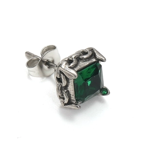 Gros plan d'une boucle d'oreille carrée en zircon vert avec détails de texture de chaîne
