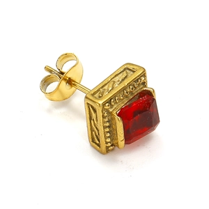 Makro-Detail des Retro-Gold-Ohrsteckers mit quadratischem rotem Zirkon und Prägemuster