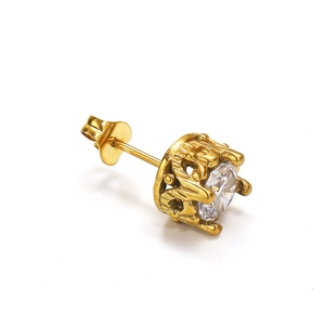 Détail macro d'une boucle d'oreille couronne dorée avec un zircon rond brillant