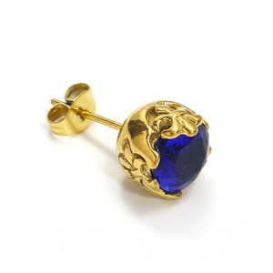 Gros plan d'une puce d'oreille rétro en acier titane doré avec une pierre bleu foncé