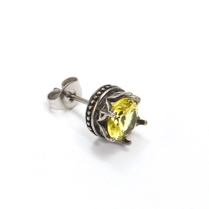 Makroaufnahme von Retro-Ohrstecker in Kronenform mit funkelndem gelbem Zirkon