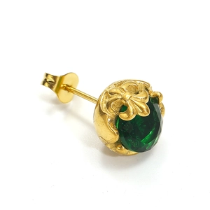 Détail d'un clou d'oreille vintage doré avec pierre verte ronde et relief fleur de lys