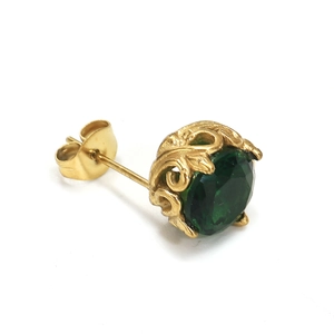 Makroaufnahme von Vintage-Ohrstecker mit Schnitzerei und rundem grünem Edelstein