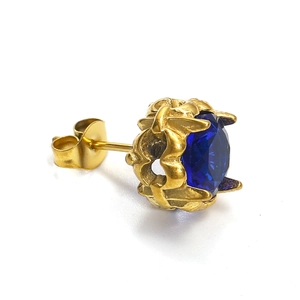Gros plan d'une boucle d'oreille en or avec une pierre de zircon ronde bleu foncé