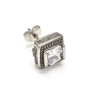 Makro-Detail des Punk-Ohrrings mit quadratischem Zirkon und Vintage-Gravur