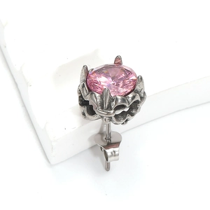 Gros plan sur un clou d'oreille gothique rétro avec zircon rose et griffes en métal